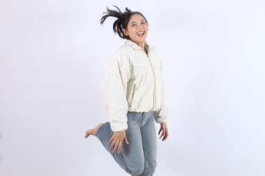 Beyaz Arkaplanda Neşeli Kadın, Heyecan ve Mutluluk İfade Ediyor. Coşku, Özgürlük ve Pozitif Enerji ile Sıçrayan.