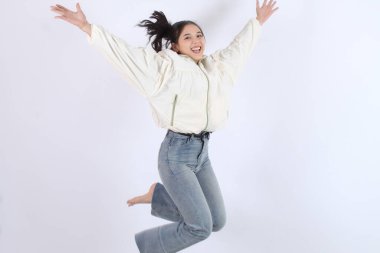 Genç Kadın Neşe, Heyecan ve Mutluluk Arkaplanda Pozitif Enerji ile Zıpladı