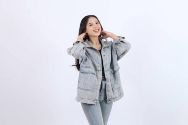 Kot Ceketli Kadın Poz Veriyor ve Beyaz Arkaplanda Kot Giyiyor Gülümsüyor