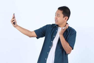 Yakışıklı Asyalı Adam Telefonu Tutuyor, Selfie Çekiyor, Sürpriz ve Şaşırtıcı İfade Ediyor, Mobil Fotoğrafı Otoportre Tekniğiyle Gösteriyor