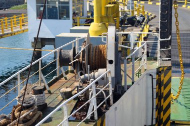 İple bağlanmış bir tekne. İp bir rıhtıma bağlı. Tekne suyun içinde.