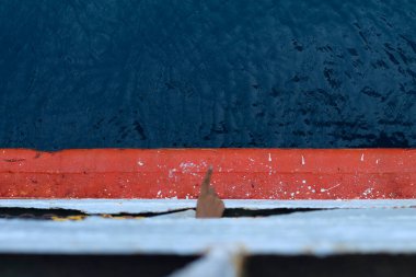 Suyu işaret eden bir el. Su mavi ve el de geminin güvertesinin tepesinden ona bakıyor.