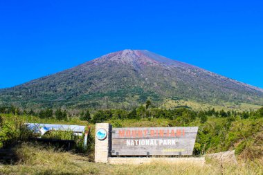 Mount Rinjani National Park sign in front of the hiking and summit departure posts. Rinjani, Lombok Indonesia 07 September 2023 clipart