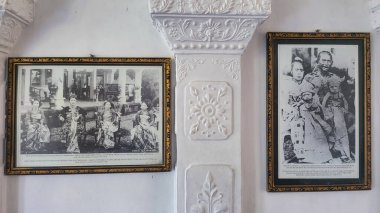 Duvarda iki kadın ve erkeğin eski resimleri asılı. İlk resim geleneksel giyinmiş bir erkek ve kadının, ikincisi Taman ujung, Karangasem Bali, Endonezya 27 Ağustos 2023