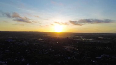 Sabahın erken saatlerinde sakin, nefes kesici bir hava manzarası. Güneş ufuktan usulca yükseliyor. Sıcak altın ve turuncu tonlarını doğanın arka planları için ideal hale getiriyor. Seyahat görüntüleri..