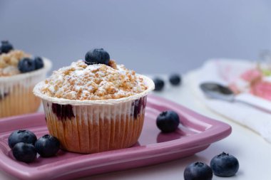 Freshly baked muffins with blueberries on a plate.