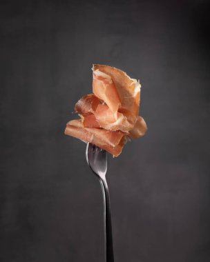 Koyu arkaplanda çatallı hamon eti