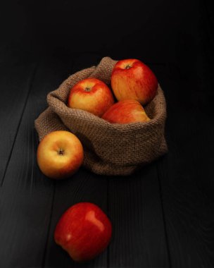 Siyah arkaplanda beş kırmızı elma.