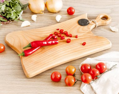 Masanın üzerinde kırmızı biberli tahta bir tahta var.