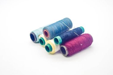 Beyaz arkaplanda izole edilmiş kopyalama alanı olan renkli dikiş ipliği yığını