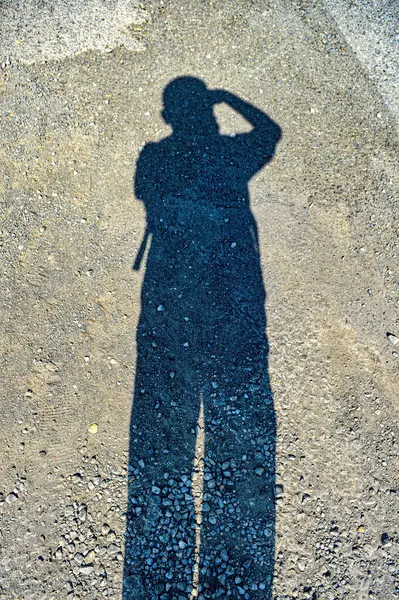 Shadow of a man taking a photo with a DSLR camera