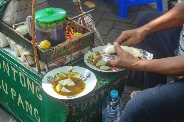 the process of serving a typical Sidoarjo food called Lontong Kupang, Translation on cart text 