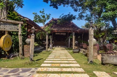 Joglo evi şeklinde geleneksel bir Java restoranının ön görüntüsü. Gong ve ahşap tahta yazı çevirileri 