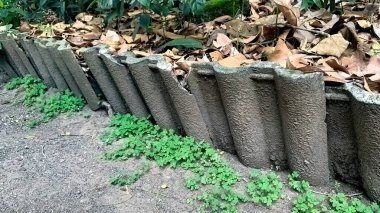 Kuru yaprak yığınını tutan kil kiremitler.