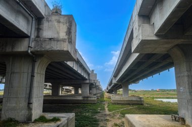 # Paralı mavi gökyüzü olan bir yol köprüsü ya da otoyolun altında #