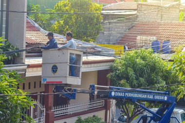 Bayındırlık İşleri Bakanlığı, 19 Aralık 2023 'te Endonezya' da bir hava aracı kullanarak karmaşık telekomünikasyon ve elektrik kabloları düzenliyor..