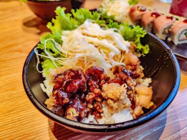 Bir porsiyon karabiberli tavuk pirinçli taze sebzeli mayonez salatası.