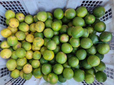 Geleneksel pazarda bir sepet limon satılıyor.