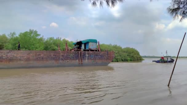 Μια Φορτηγίδα Που Τραβιέται Από Ένα Ρυμουλκό Διασχίζει Ένα Ποτάμι — Αρχείο Βίντεο