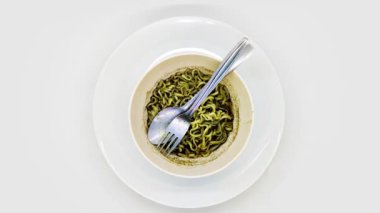 Beyaz arka planda izole edilmiş siyah soslu, rawon aromalı hazır şehriye kâsesinin dönüşünü veya görüntüsünü gösterir.