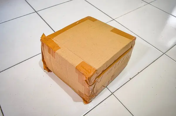 Cardboard boxes insulated with tape for sending packages lay on the floor