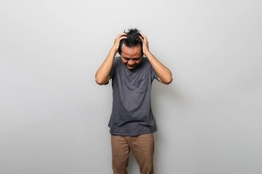 Asyalı bir adam stresli ya da hayal kırıklığı gibi baş ağrısı çekiyor.