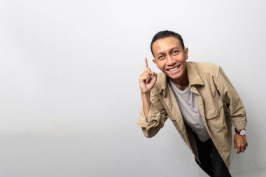 Bir adam işaret parmağını yukarı kaldırır, sanki bir fikri ya da düşüncesi varmış gibi.