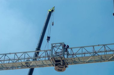 Teleskopik vinçlerle demir kaynaklayıp birleştiren inşaat işçileri, 16 Mayıs 2024.