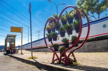 City planning decoration on the side of the main road, a red love heart symbol made of iron, decorated with vines, Indonesia, 16 May 2024. clipart