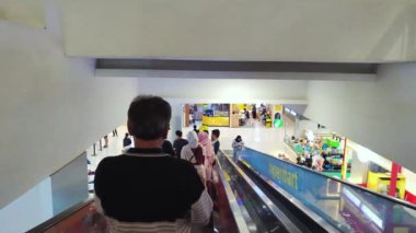 28 Mayıs 2024 'te bir alışveriş merkezinde, havaalanında, metro istasyonunda veya meydanda yürüyen merdivenlere binen pek çok insan var..