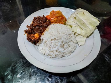Endonezya 'da bir büfede acı biber soslu ve lahana salatalı bir porsiyon rendang pilavı.