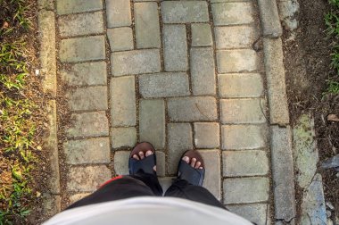 Adam asfalt zeminde bir çizgiyi geçiyor. Bir kaldırım taşı sokağına bakıyorum..