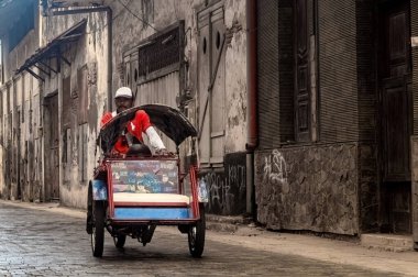 Taksicilik yapan bir adamın işi, 20 Haziran 2024 'te Surabaya, Endonezya' daki ailesine bakacak yolcular aramaktır..