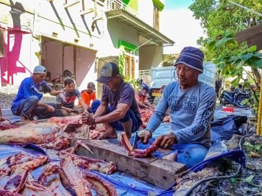 Kurban Bayramı ya da Kurban Bayramı için 18 Haziran 2024 'te bir grup insan sığır eti kesiyor..