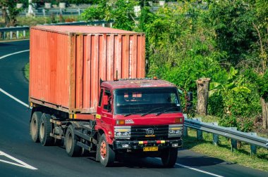 Surabaya Gresik otobanından geçen bir kamyon ya da konteynır kamyonu, 16 Temmuz 2024 'te dünya çapında ihracat ve ithalat için tam yük lojistik taşıyordu..