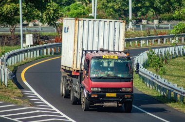 Surabaya Gresik otobanından geçen bir kamyon ya da konteynır kamyonu, 16 Temmuz 2024 'te dünya çapında ihracat ve ithalat için tam yük lojistik taşıyordu..