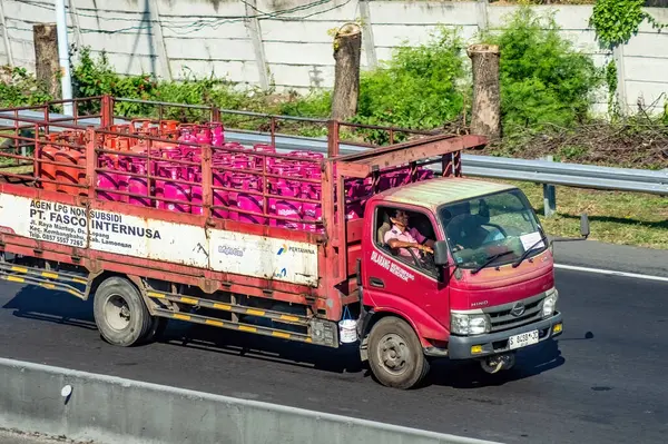 stock image a Hino truck that transports and delivers bright gas or pink LPG on toll roads, Indonesia, 16 July 2024.