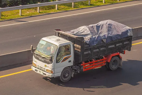 stock image a mining dump truck carrying sand passing on the toll road, Indonesia, 16 July 2024.