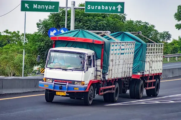 stock image a trailer truck or articulated lorry passing on the Surabaya Gresik toll road carrying a full load of logistics, Indonesia, 16 July 2024.