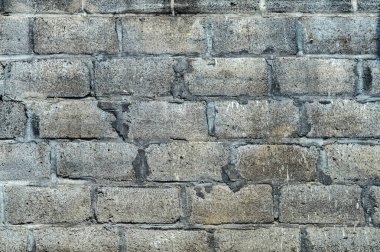 Görünür çatlakları ve kusurları olan yıpranmış beton bir duvar..