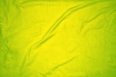 Karmaşık kıvrımları ve ayrıntılı kırışıklıkları olan canlı yeşil kumaşı kapat, tasarım ve arkaplan kullanımı için mükemmel.