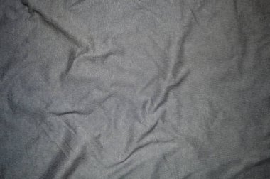 Kırışık gri kumaşı, karmaşık dokuma detaylarıyla kapatın, arka plan ya da tasarım için mükemmel. Doku ve buruşukluk maddeye derinlik ve ilgi ekler.