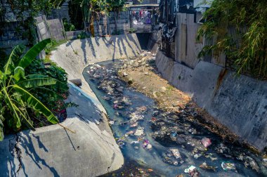 Kirli şehir nehri çöp ve molozlarla tıkanmış, çevre sorunları ve atık yönetimi sorunları vurgulanmış, Endonezya, 18 Eylül 2024.