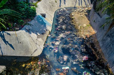 Kirli şehir nehri çöp ve molozlarla tıkanmış, çevre sorunları ve atık yönetimi sorunları vurgulanmış, Endonezya, 18 Eylül 2024.