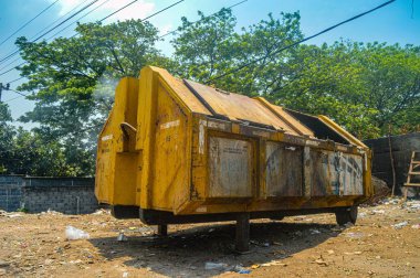 Grafiti ile kaplanmış kentsel atık yönetimi sahnesi sarı çöp, dağınık çöp ve yanan çöpler açık mavi gökyüzü, Endonezya, 18 Eylül 2024 karşı.