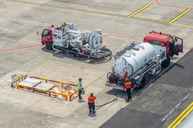 Havaalanı personeli, havacılık operasyonlarında güvenlik ve verimliliği sağlamak için bir uçağa yakıt ikmali yapıyor. Pürüzsüz ve güvenli hava yolculuğu için gerekli Surabaya, 22 Eylül 2024.