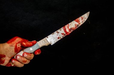 Kanlı bir el, arka planda kana bulanmış bir bıçağı kavrıyor. Şiddeti ve tehlikeyi simgeliyor.