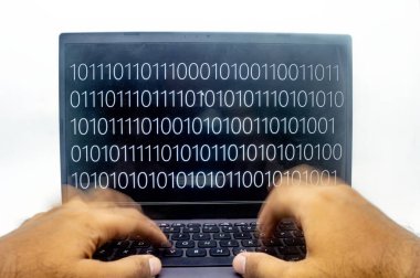 Bir çift el, hızlı tempolu kodlamayı veya hacklemeyi sembolize ederek ekranda gösterilen ikili kodlu bir dizüstü bilgisayarın klavyesinde hızla yazıyor. Teknoloji, programlama veya veri kavramları için mükemmel
