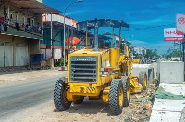 Komatsu dereceli bir şehir merkezinde yol yapımı. Altyapı geliştirme ve kentsel planlamayla ilgili yazılar için ideal, Endonezya, 31 Ekim 2024