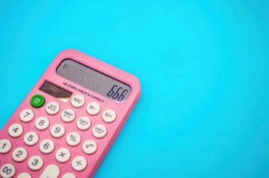 Beyaz düğmeli pembe bir hesap makinesi, resmin etrafında geniş bir kopya alanı bulunan mavi bir arkaplanda 666 sayısını gösterir.